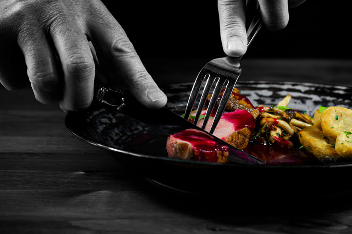 Diner cutting into a plated course