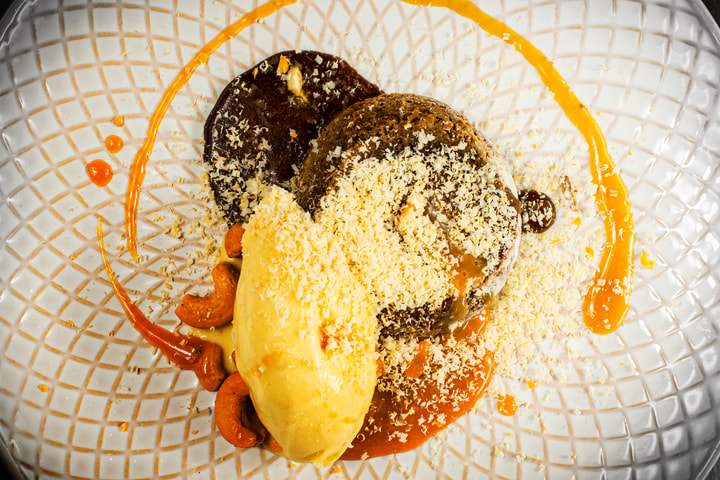 Lava cake with orange sauce on a patterned plate
