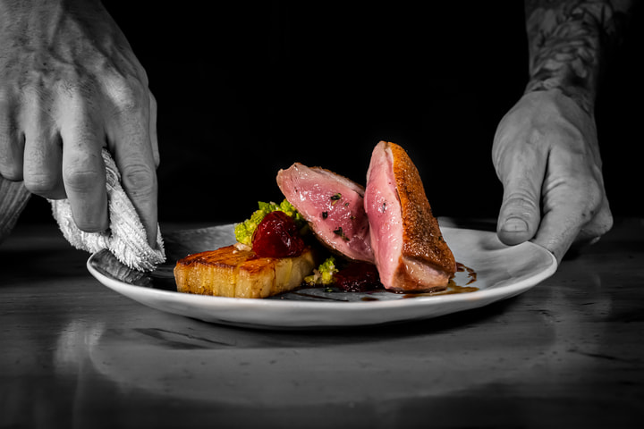 Hands plating sliced duck breast