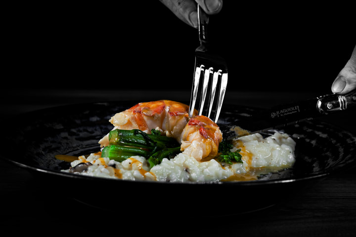 Fork resting on a lobster and risotto plate