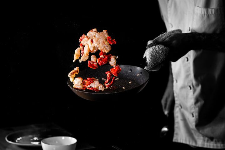 Lobster and tomatoes tossed in a pan