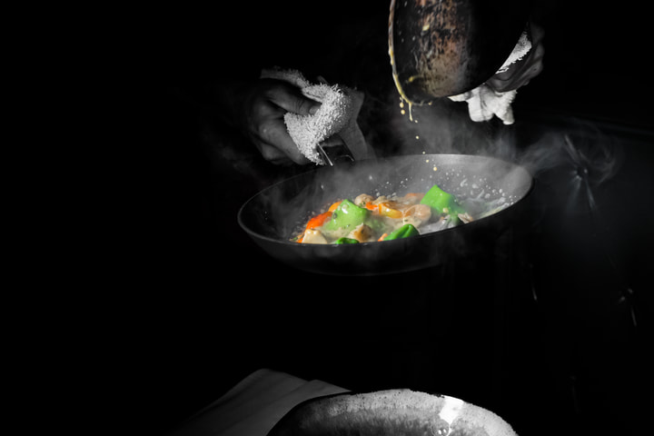 Hands over a pan of vegetables