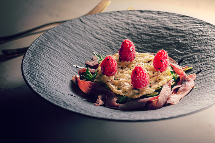 Dish topped with raspberries on a slate plate