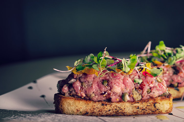Tartare toast against a blue background