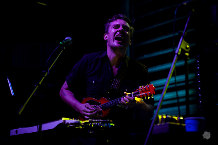 Guitarist singing under blue light