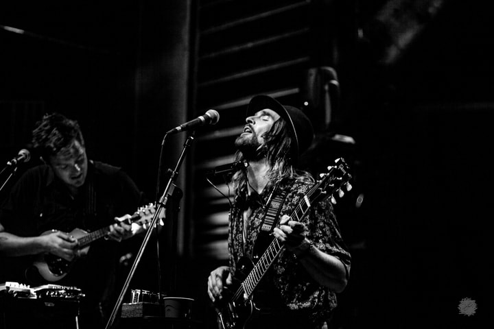 Two guitarists on stage, black and white