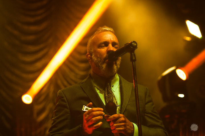 Singer with harmonica under amber beams
