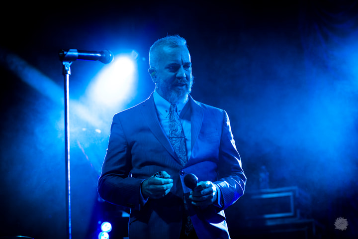 Singer in a suit under blue light