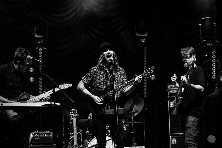 Three musicians on stage, black and white