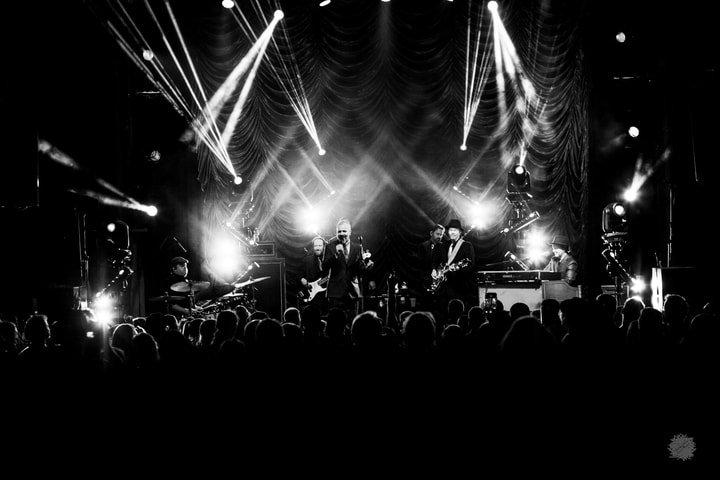 Wide view of the stage and crowd, black and white